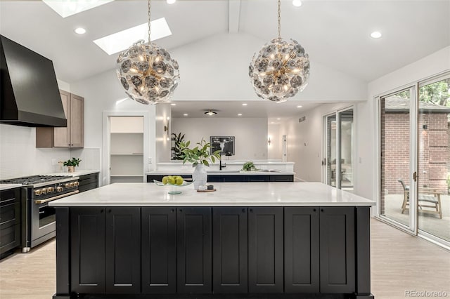 5401 E Dakota Ave Unit 22, Denver, CO 80246 - kitchen with high end stainless steel range, wall chimney exhaust hood, a skylight, light countertops, and light wood finished floors