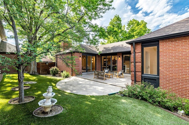 5401 E Dakota Ave Unit 22, Denver, CO 80246 - rear view of house with brick siding, a patio, and roof with shingles