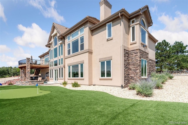 rear view of property with a lawn and a wooden deck