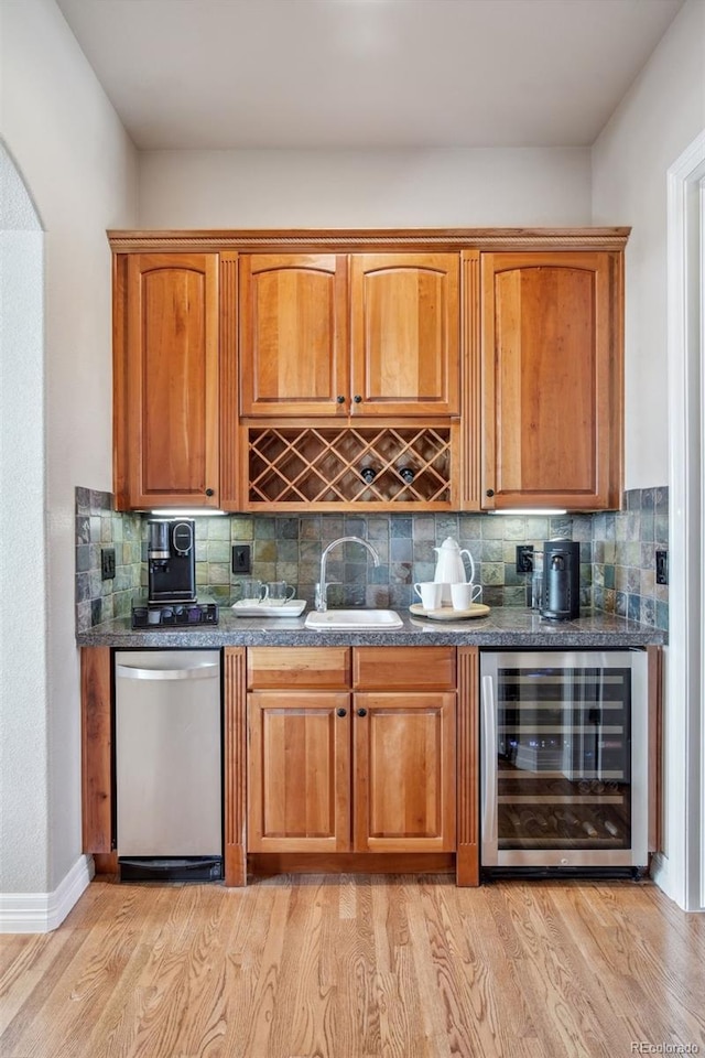 bar featuring light wood-type flooring, sink, wine cooler, decorative backsplash, and stainless steel dishwasher