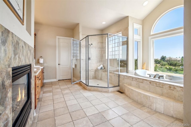 bathroom with tile patterned flooring, independent shower and bath, vaulted ceiling, and vanity