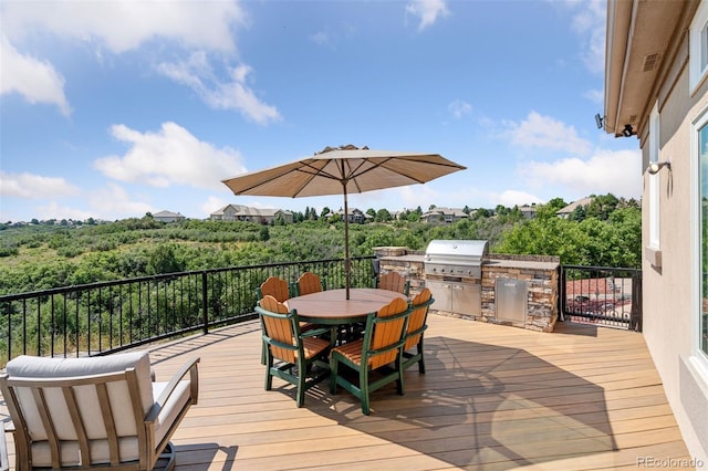 wooden terrace featuring an outdoor kitchen and area for grilling