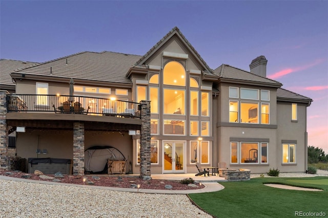 back house at dusk featuring an outdoor fire pit, a yard, and a patio area