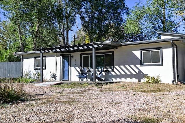 rear view of house featuring a pergola and a patio