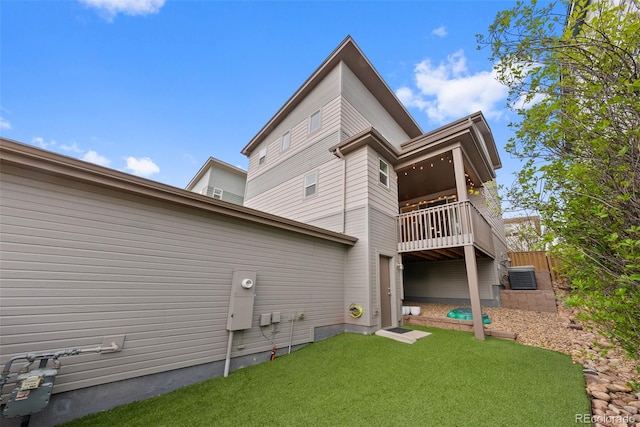 rear view of property featuring a yard and a balcony