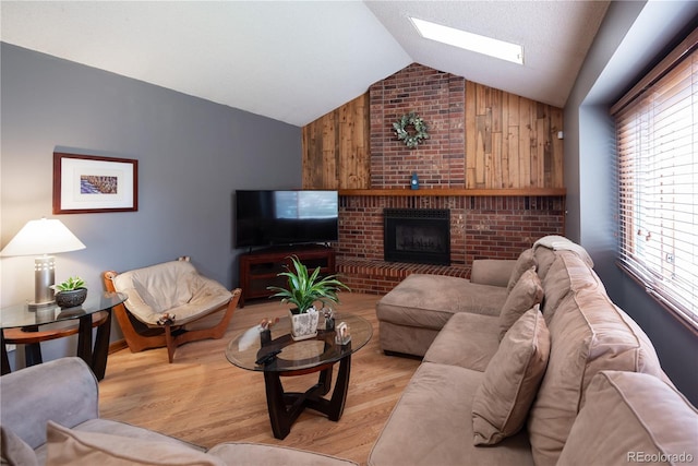17530 E Caspian Pl, Aurora, CO 80013 - living room with vaulted ceiling, a skylight, light wood-style flooring, and a fireplace