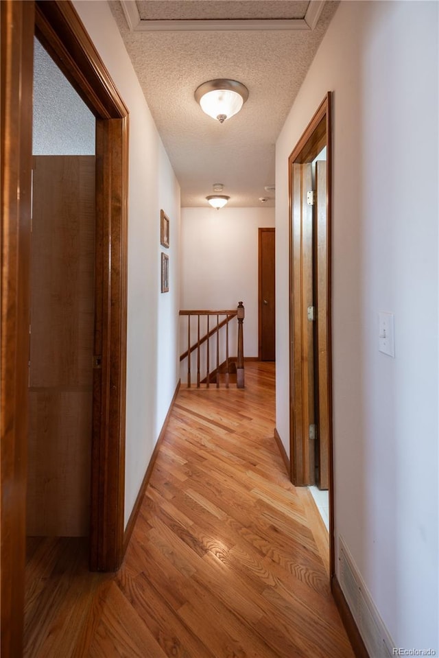 17530 E Caspian Pl, Aurora, CO 80013 - hallway featuring an upstairs landing, light wood-style flooring, and a textured ceiling