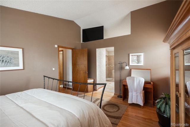 17530 E Caspian Pl, Aurora, CO 80013 - bedroom with wood finished floors, high vaulted ceiling, and ensuite bathroom