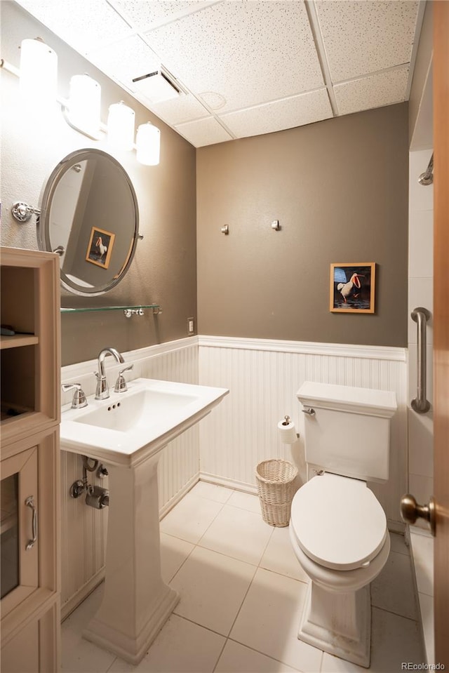 17530 E Caspian Pl, Aurora, CO 80013 - half bath featuring a drop ceiling, a wainscoted wall, and tile patterned flooring