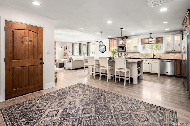 kitchen featuring a sink, built in appliances, a wealth of natural light, and a breakfast bar