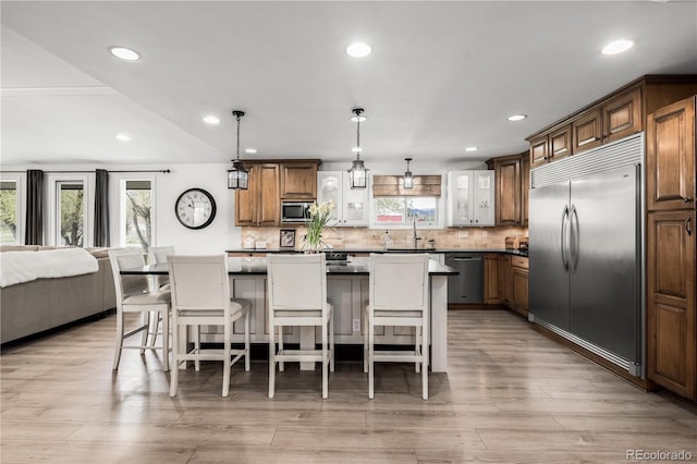 kitchen with a breakfast bar area, a center island, a sink, backsplash, and stainless steel appliances