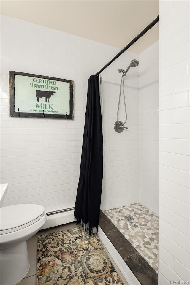 full bathroom featuring tile patterned flooring, a baseboard radiator, a tile shower, and toilet