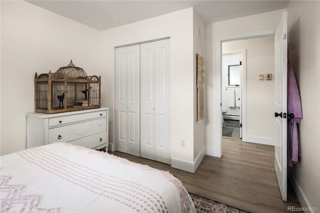 bedroom featuring baseboards, a baseboard radiator, wood finished floors, and a closet
