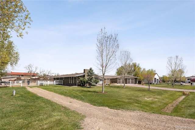 surrounding community featuring a yard, an attached garage, fence, and driveway