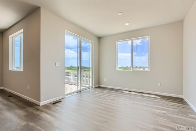 unfurnished room with hardwood / wood-style floors