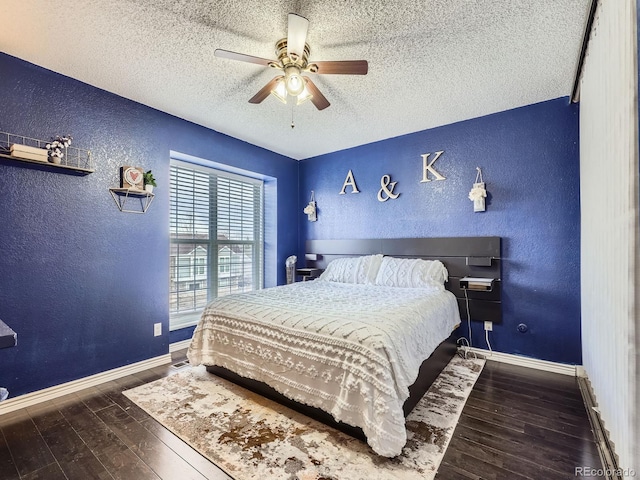 bedroom with ceiling fan, dark wood-type flooring, and a textured ceiling