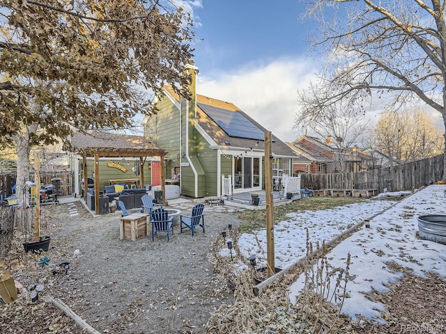 snow covered property featuring a patio area and solar panels