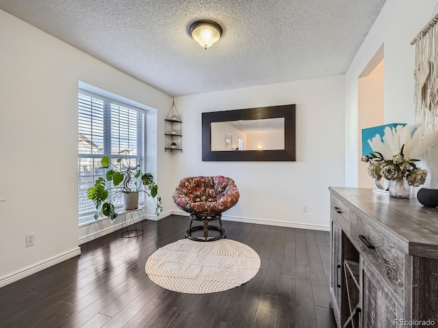 sitting room with a textured ceiling and dark hardwood / wood-style floors