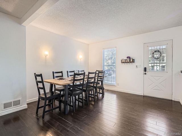 dining room featuring a textured ceiling and dark wood-type flooring