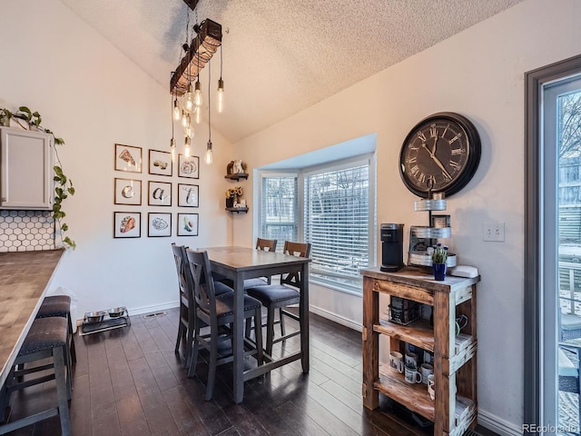 dining area featuring a textured ceiling, dark hardwood / wood-style floors, and lofted ceiling