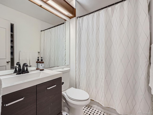 bathroom with tile patterned floors, vanity, toilet, and walk in shower