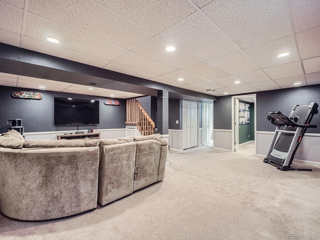 living room with a drop ceiling and carpet floors