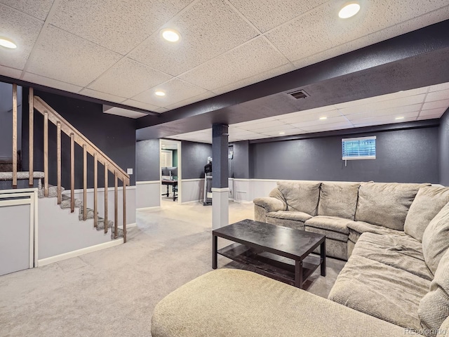 living room featuring a paneled ceiling and carpet