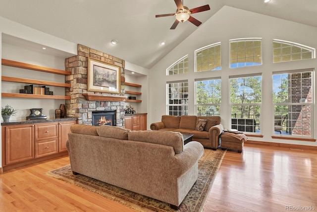 11268 Bell Cross Cir, Parker, CO 80138 - living room featuring a stone fireplace, ceiling fan, light wood-type flooring, high vaulted ceiling, and recessed lighting