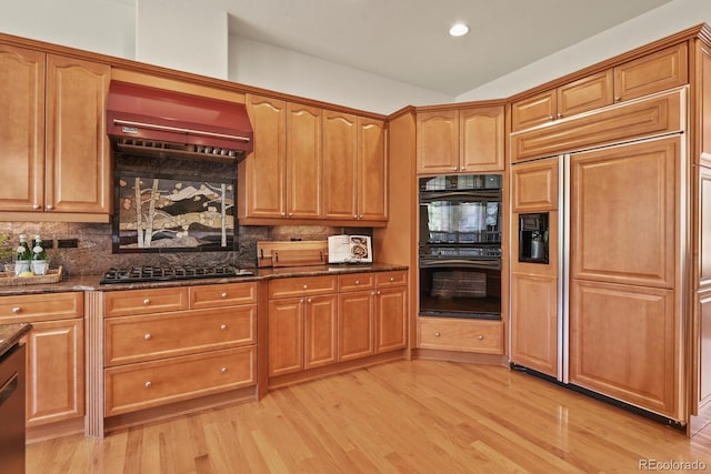 11268 Bell Cross Cir, Parker, CO 80138 - kitchen with stainless steel gas cooktop, paneled fridge, light wood-type flooring, dark stone counters, and recessed lighting