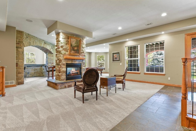 11268 Bell Cross Cir, Parker, CO 80138 - living area featuring a stone fireplace, stone tile flooring, recessed lighting, and arched walkways