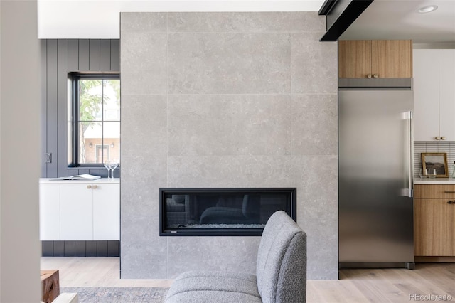 interior space featuring hardwood / wood-style flooring, stainless steel built in fridge, and a fireplace