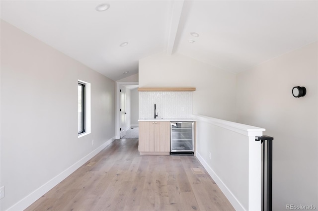 bar featuring light wood-type flooring, lofted ceiling with beams, wine cooler, and sink