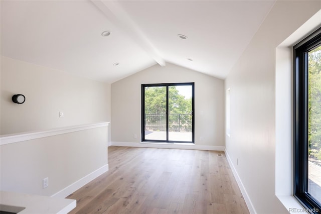 interior space with light wood-type flooring and lofted ceiling with beams