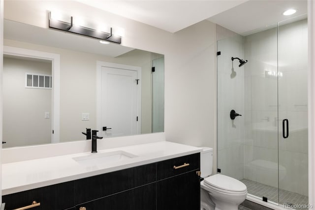 bathroom with vanity, toilet, and a shower with shower door