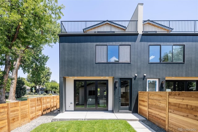 back of house with a balcony and french doors