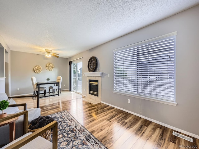 5154 E 126th Ct, Thornton, CO 80241 - living area featuring a textured ceiling, light wood-type flooring, ceiling fan, and a fireplace
