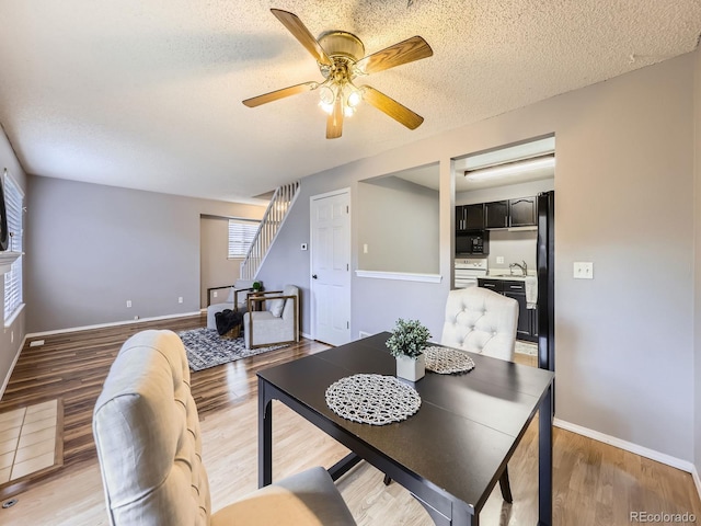 5154 E 126th Ct, Thornton, CO 80241 - dining room with stairway, a ceiling fan, light wood-style floors, and a textured ceiling