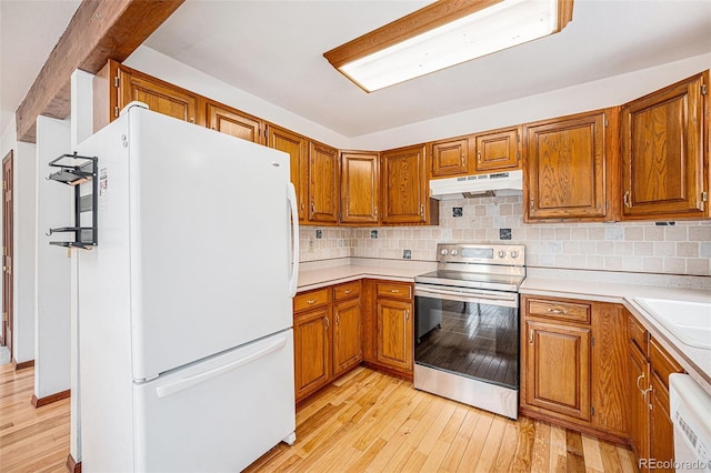 10858 Norton Ave, Conifer, CO 80433 - kitchen featuring brown cabinetry, light wood-style flooring, under cabinet range hood, white appliances, and decorative backsplash