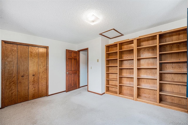 10858 Norton Ave, Conifer, CO 80433 - unfurnished bedroom with a closet, a textured ceiling, baseboards, attic access, and carpet floors