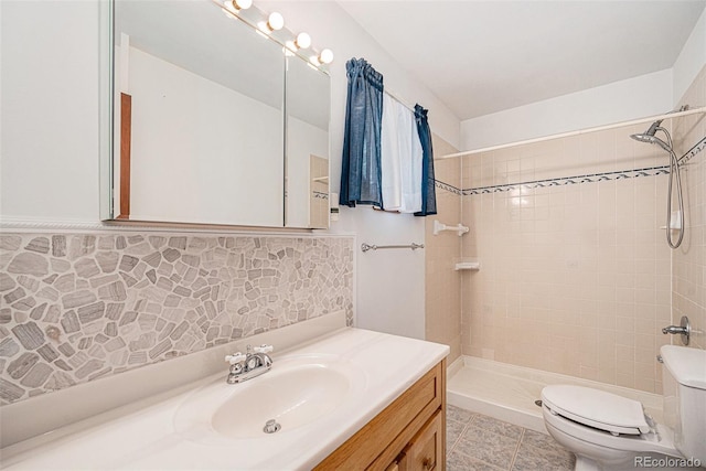 10858 Norton Ave, Conifer, CO 80433 - bathroom with tile patterned floors, a tile shower, toilet, vanity, and decorative backsplash