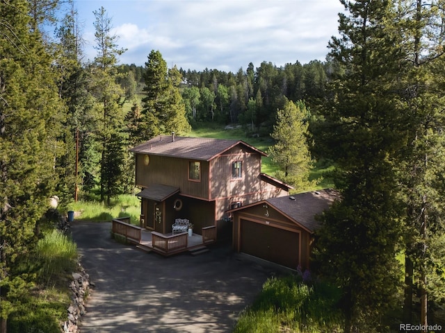 10858 Norton Ave, Conifer, CO 80433 - rustic home with a view of trees, a shingled roof, asphalt driveway, and a wooden deck