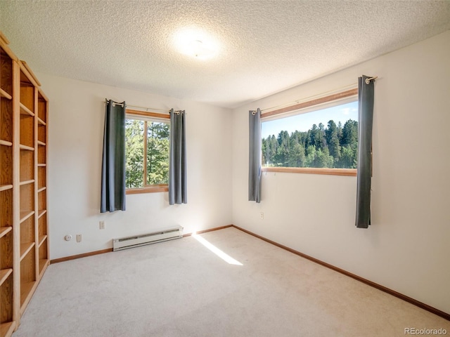 10858 Norton Ave, Conifer, CO 80433 - spare room featuring a baseboard heating unit, healthy amount of natural light, carpet floors, and a textured ceiling