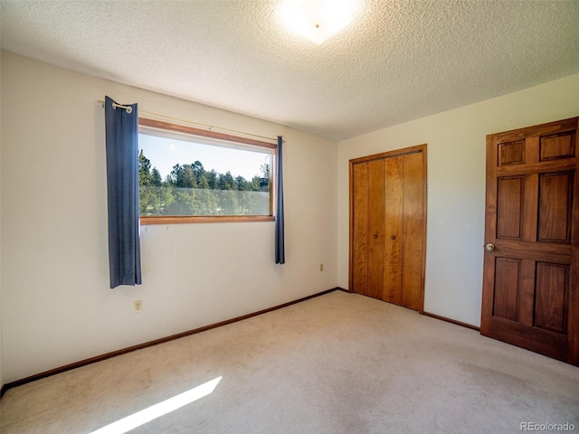 10858 Norton Ave, Conifer, CO 80433 - unfurnished bedroom featuring light carpet, a textured ceiling, and a closet