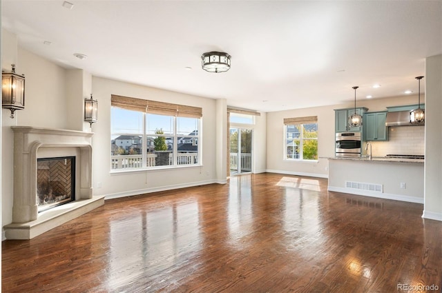 unfurnished living room with dark hardwood / wood-style floors and sink