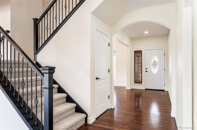 foyer entrance featuring dark wood-type flooring and vaulted ceiling