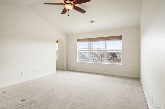 empty room with light colored carpet, vaulted ceiling, and ceiling fan