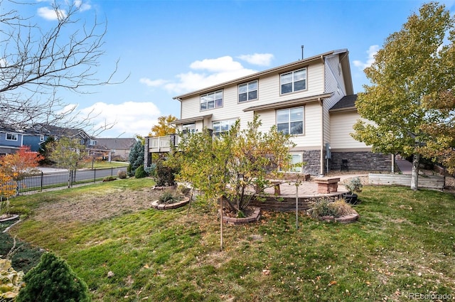 back of house with a lawn and a wooden deck