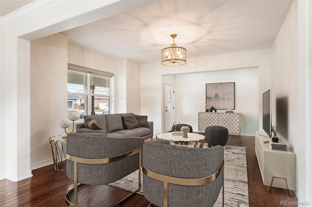 living room with dark hardwood / wood-style floors, ornamental molding, and a chandelier