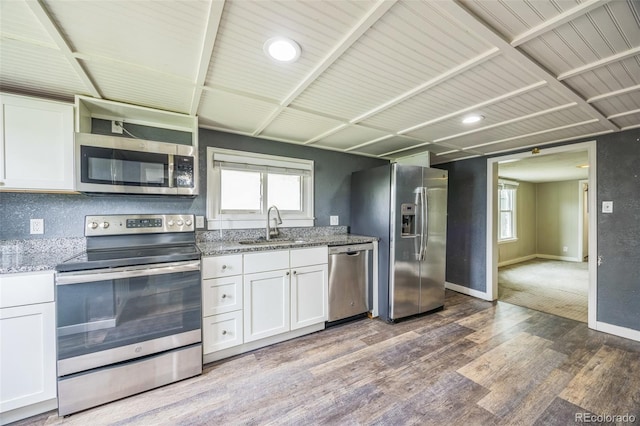 524 N 4th Ave, Sterling, CO 80751 - kitchen featuring stainless steel appliances, wood finished floors, white cabinetry, a sink, and baseboards