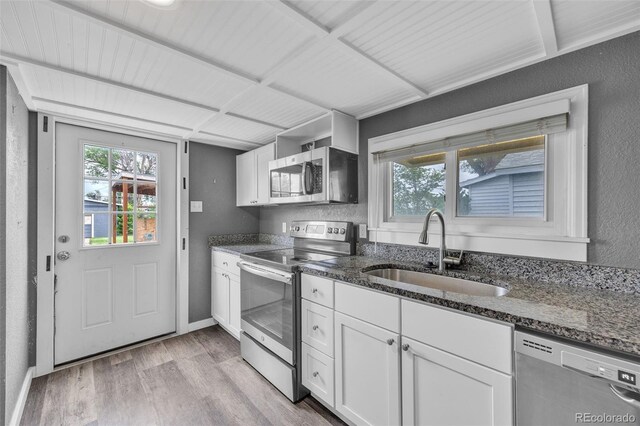 524 N 4th Ave, Sterling, CO 80751 - kitchen featuring stainless steel appliances, a sink, dark stone countertops, light wood-type flooring, and a textured wall